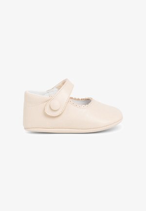 Chaussure en cuir pour bébé de couleur beige clair avec un bout rond, des bords festonnés et une sangle avec un système de fermeture à bouton rond. Doublure intérieure douce.