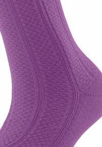 Lila Socke mit strukturiertem Muster, ausgestattet mit einem gerippten Bündchen und verstärkter Ferse. Das Material erscheint weich und dehnbar.