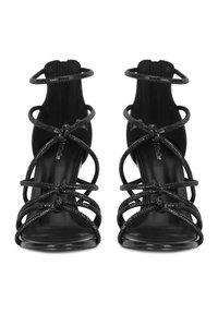 Sandalias negras de tacón alto con tiras intrincadas adornadas con diamantes de imitación, diseño de punta abierta y suela lisa y brillante.