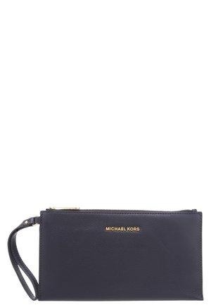 Pochette bracelet Michael Kors en cuir noir avec fermeture éclair dorée et sangle poignet, compacte et rectangulaire.
