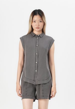 Grijze mouwloze button-up shirt met een kraag en een gebogen zoom, gecombineerd met bijpassende shorts. Gemaakt van zacht materiaal met zichtbare stikseldetails.