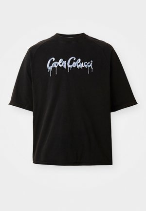 Sort oversized t-shirt med korte ærmer og "Carla Colucci" logo i hvid, der hænger ned i malestil på tværs af brystet.