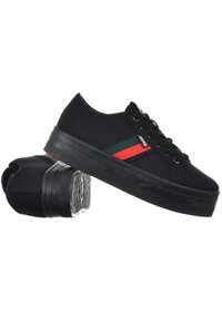 Baskets noires en toile avec une semelle en caoutchouc, présentant un accent rayé rouge et vert sur le côté, et des lacets noirs. Semelle texturée pour une meilleure adhérence.