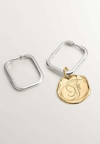 Pendientes metálicos cuadrados con un acabado plateado pulido, que presentan un charm texturizado dorado inscrito con un diseño de letra en cursiva.
