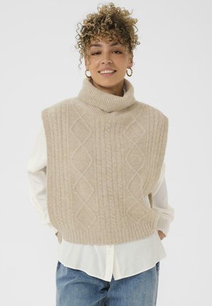 Beige knitted sleeveless turtleneck sweater with a cable knit pattern and ribbed edges, layered over a white shirt.