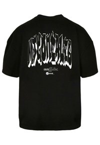 Schwarzes Baumwoll-T-Shirt mit kräftigem weißen Graffiti-Text auf dem Rücken. Kurze Ärmel und lockere Passform. Keine vorderseitige Grafik sichtbar.