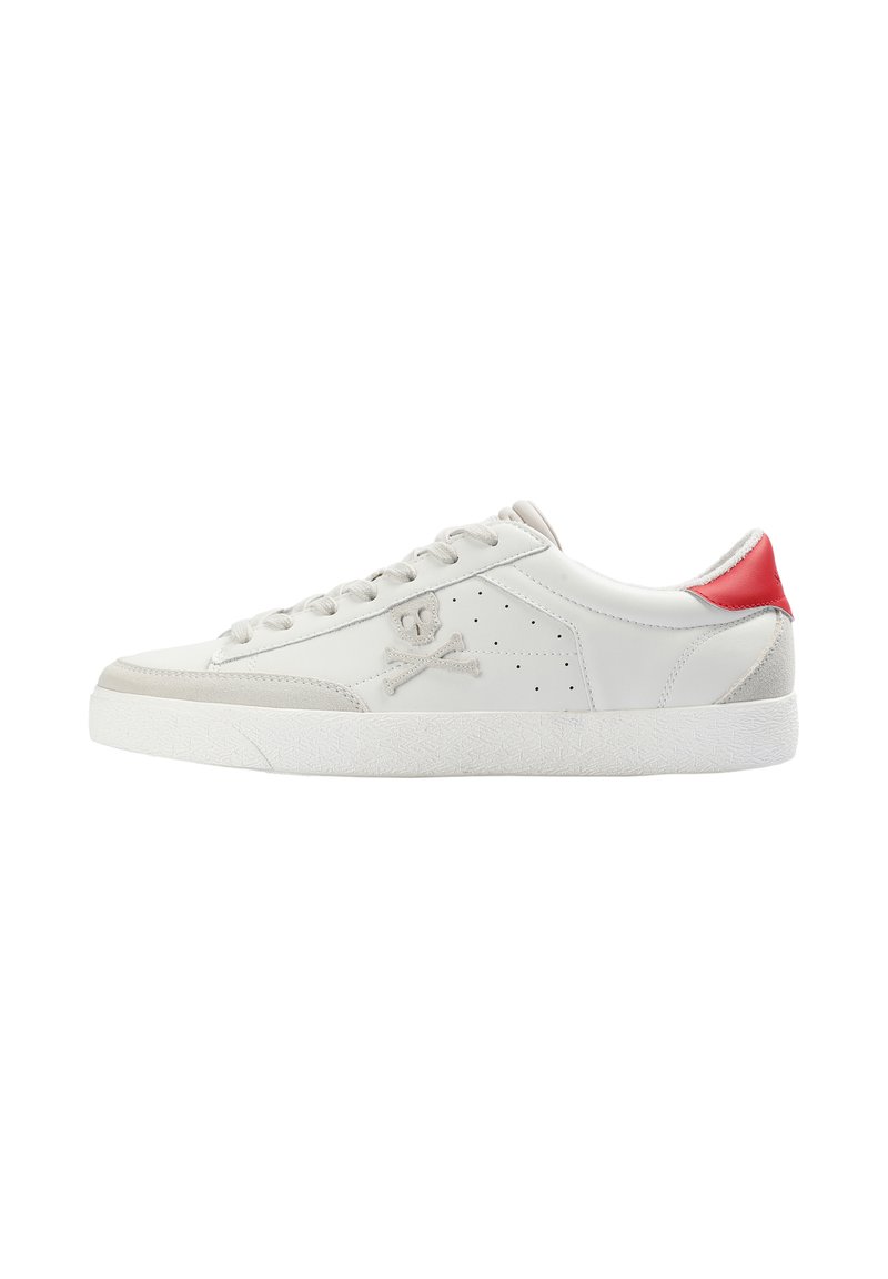 Zapatilla baja blanca con acentos de ante gris claro, una lengüeta trasera roja, logo de calavera y huesos cruzados en el lateral, y suela de goma blanca.