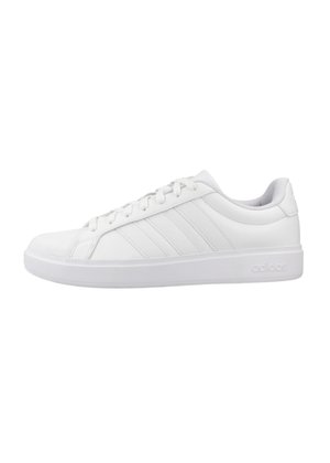 Zapatilla Adidas blanca de perfil bajo con diseño de cordones, tres rayas laterales y suela con marca, mostrada en perfil derecho sobre fondo blanco.