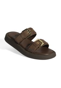 Sandale en cuir marron avec deux larges brides ornées de boucles dorées. Semelle épaisse et texturée sombre pour plus de confort et de soutien.