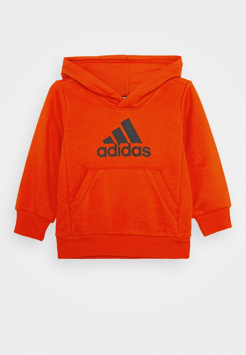 Oranje hoodie van zachte stof, met een kangoeroezak en een zwart Adidas-logo op de voorkant. Relaxte pasvorm, ribgebreide manchetten.