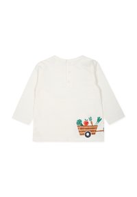 Chemise à manches longues, couleur blanc cassé, avec fermeture par boutons au dos. Présente un chariot en bois illustré avec des fruits et légumes sur le côté.
