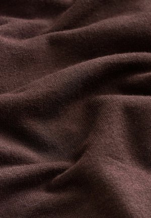 Brunt stof med en blød, tekstureret vævning, der viser subtile folder og en glat finish, hvilket indikerer letvægts- og fleksibelt materiale.