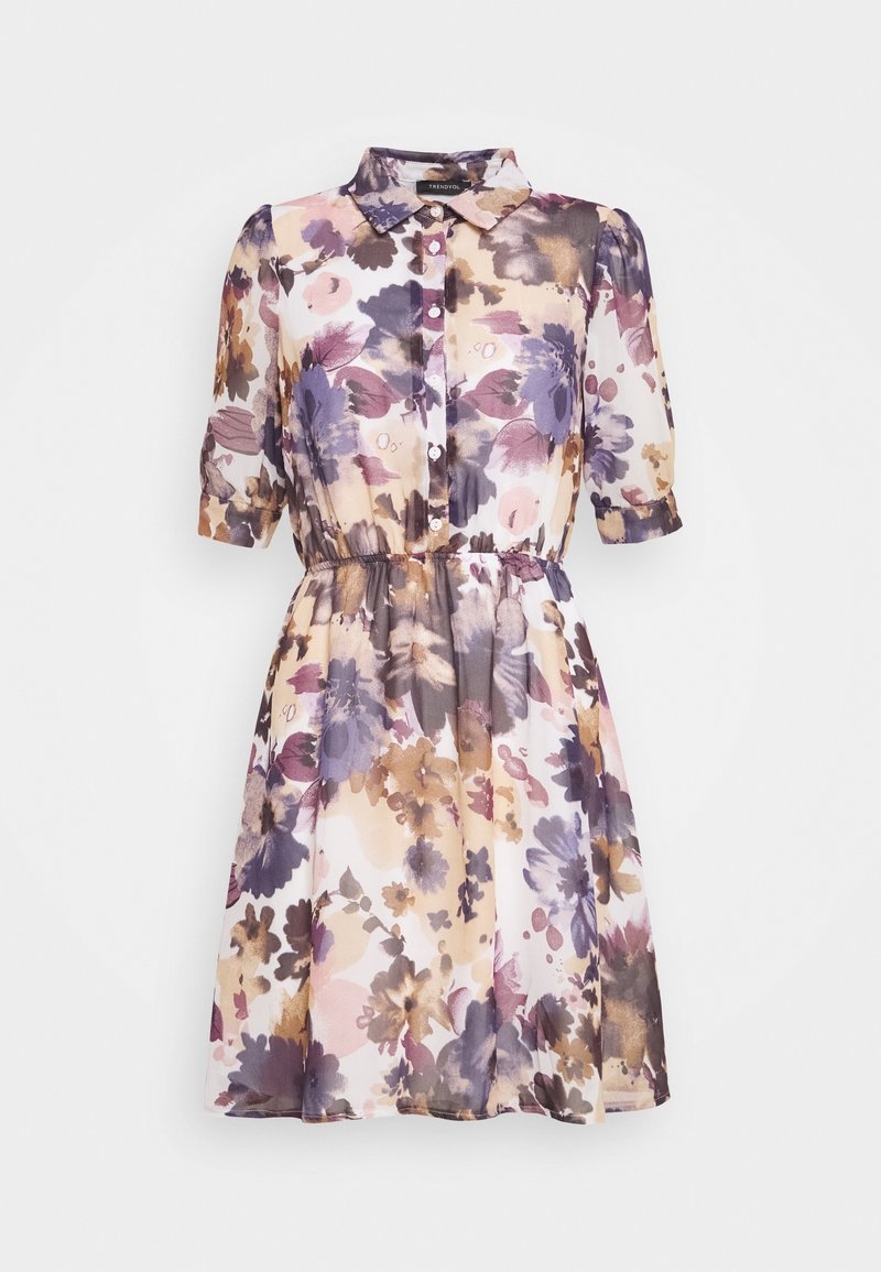 Robe fleurie avec un col, des manches courtes, une taille élastique et un mélange de tons violets, bruns et pêches dans un tissu transparent.