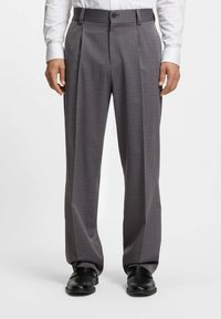 Grijs geruit broek met een gestructureerde stof, voorzien van een geplooide voorkant, recht model en een sluiting met een enkele knoop.