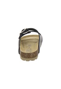 Black sandal with two adjustable straps, cork footbed, and textured rubber outsole. Flat heel and minimalist design.