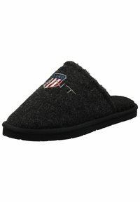 Zapatillas de lana negras con una textura suave, diseño curvado, que cuentan con un parche de logo con acentos en rojo, blanco y azul, y una suela de goma negra.