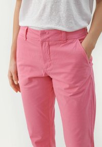 Rosa bomullbyxor med en slät yta, rak passform och sidofickor. Har ett standard midjeband och minimal sömdetalj.