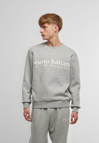 Gray sweatshirt with crew neck and ribbed cuffs, featuring white text "bruno banani NOT FOR EVERYBODY" across the chest.