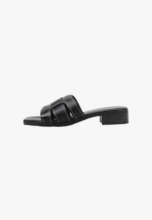 Sandalia negra tipo slide con punta abierta, tiras de cuero cosidas y tacón bajo de bloque.