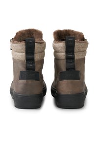 Bruine enkellaarsjes met een gestructureerde stoffen boord, bontvoering en zwarte rubberen zolen. Bevat een merklabel aan de achterkant en een zijrits.