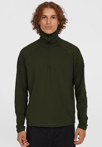 Pullover lungo verde scuro con maniche lunghe, colletto alto e chiusura a metà zip, con cuciture in contrasto. Presenta un design aderente e una trama morbida.