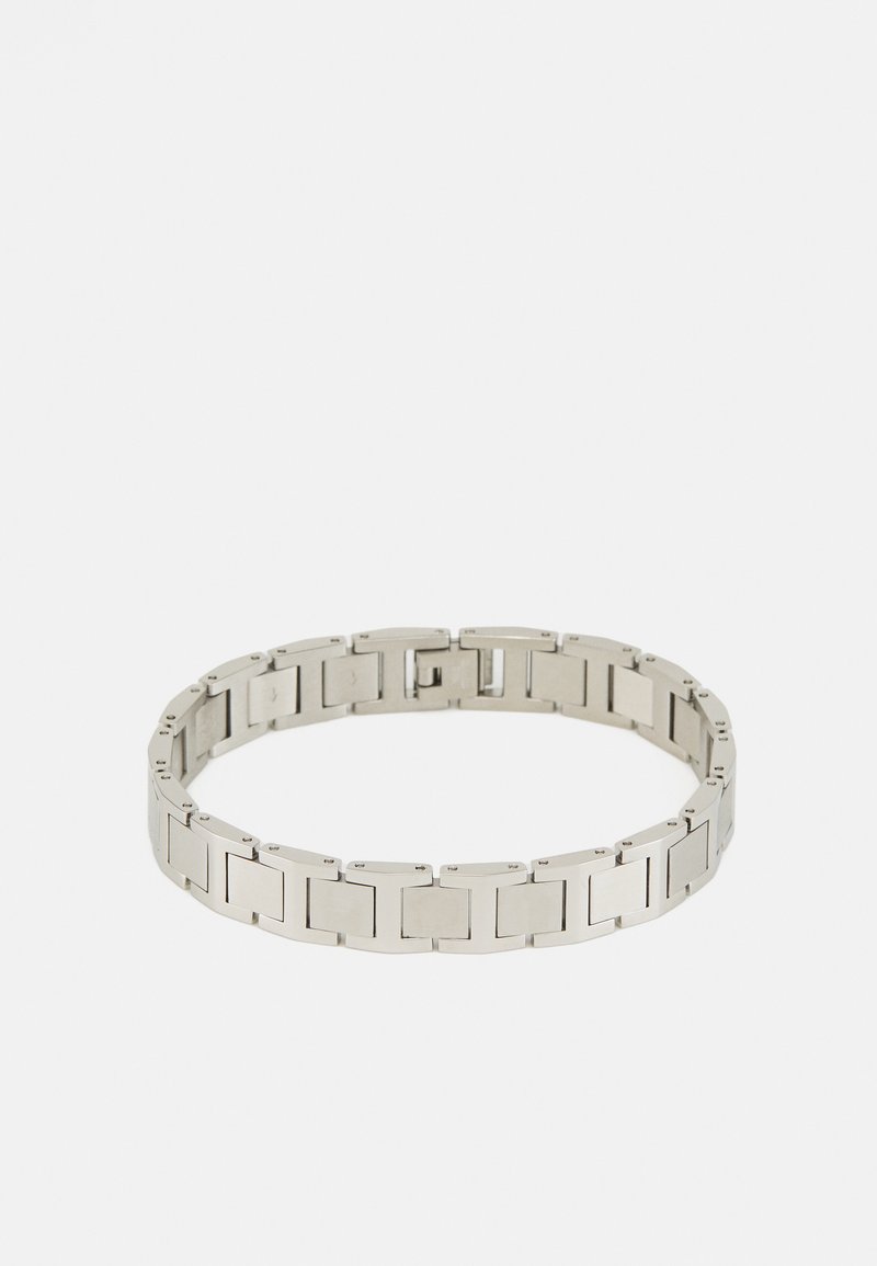 Bracelet en métal argenté avec des maillons rectangulaires entrelacés, finition lisse et polie, et un mécanisme de fermeture sécurisé.