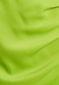 Jasno limonkowo-zielony materiał o gładkiej, satynowej fakturze, z delikatnym drapowaniem i subtelnymi zmarszczkami w całej powierzchni.