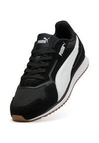 Zapatilla deportiva en blanco y negro con materiales de ante, sintético y malla; cuello acolchado; suela de caucho; logo de Puma destacado en la lengüeta.
