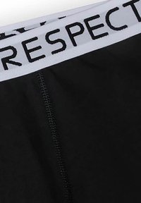 Czarne majtki z białym elastycznym pasem z napisem "RESPECT" w wyraźnych czarnych literach. Gładki materiał z widocznym szwem.