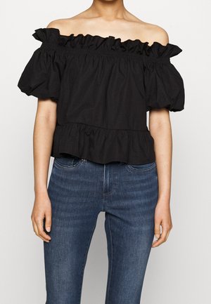 Zwarte off-shoulder top met rimpelige halslijn en pofmouwen, voorzien van een gelaagde zoom en een zachte, gestructureerde stof. In combinatie met denim jeans.