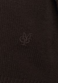 Dunkelbrauner gestrickter Pullover mit einem dezenten geprägten Logo in der unteren linken Ecke, der einen strukturierten Stoff mit feiner Rippung zeigt.