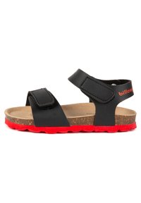 Sandale en cuir noir avec deux brides ajustables, semelle en liège et semelle extérieure en caoutchouc rouge. Design simple avec une fermeture velcro sur chaque bride.