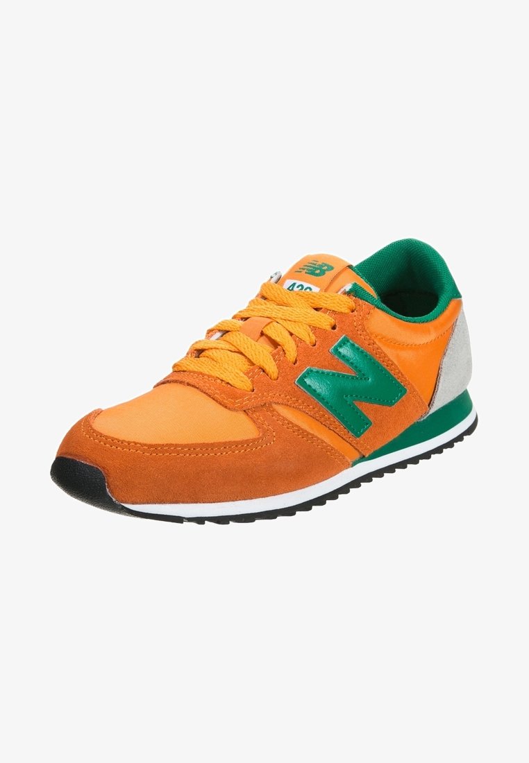 Pomarańczowe i zielone sneakersy z zamszową i tekstylną cholewką, gumową podeszwą, okrągłym czubkiem oraz wyraźnym zielonym logo 'N' po boku.