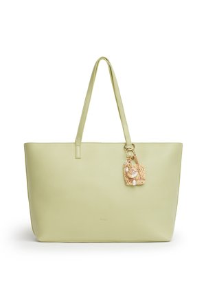 Borsa tote in pelle verde chiaro con due manici lunghi e un piccolo portachiavi intrecciato con conchiglie attaccato a un manico.