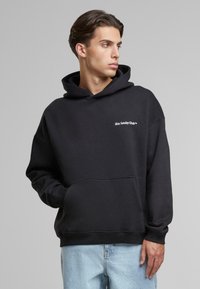 Black hooded sweatshirt featuring a front pocket and embroidered "Slow Sunday Club" logo. Relaxed fit with ribbed cuffs and hem.