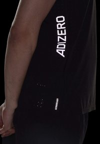 Czarny sportowy t-shirt z odblaskowym logo "ADIZERO" i "AEROREADY", o gładkiej fakturze i perforowanym wzorze zapewniającym wentylację.