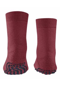 Czerwone, wełniane skarpetki z prążkowanym mankietem i antypoślizgowymi gumowymi gripami na podeszwie, charakteryzujące się fakturowaną powierzchnią i bezszwowym wykończeniem palców.