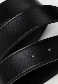 Schwarzer Leder Gürtel mit strukturiertem Finish, sichtbaren Nähten und mehreren Löchern zur Anpassung, die in überlappenden Schlaufen angeordnet sind.