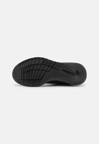 Černá sportovní podrážka s drážkovaným gumovým povrchem pro trakci; obsahuje kruhový vzor na patě a vyražené logo Nike.