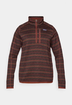 Sweater with a high collar, half-zip closure, features a red, black, and green zigzag pattern, made from textured knit fabric.