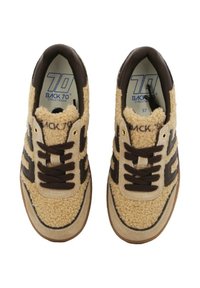 Sneakers con una parte superiore fluffy beige, dettagli in pelle marrone e un sistema di lacci marrone scuro. Presentano una suola in gomma marrone chiaro e un marchio all'interno.