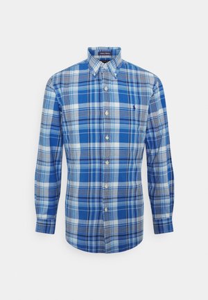 Chemise homme à manches longues avec boutons, motif à carreaux bleu et blanc et col boutonné.