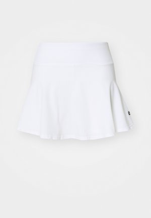 Jupe-short blanche avec une silhouette évasée, faite en tissu doux. Elle présente une taille large et un logo subtil en bas à droite.