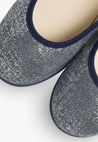 Ballerine grigie scintillanti con tomaia testurizzata, bordature blu navy e punta arrotondata. Fodera interna liscia con dettagli di cucitura minimi.