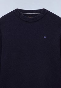 Pull en laine bleu marine foncé avec col rond côtelé et petit logo carré sur le côté gauche de la poitrine.