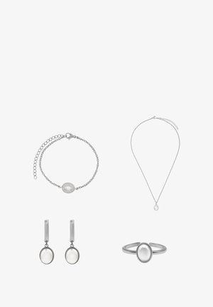 Ensemble de bijoux en argent comprenant un bracelet, un collier, des boucles d'oreilles et une bague ornés d'accents de perles ovales sur des chaînes texturées.
