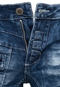 Dark blue denim jeans with visible zipper, button, and stitching details, shown partially unzipped and unbuttoned.