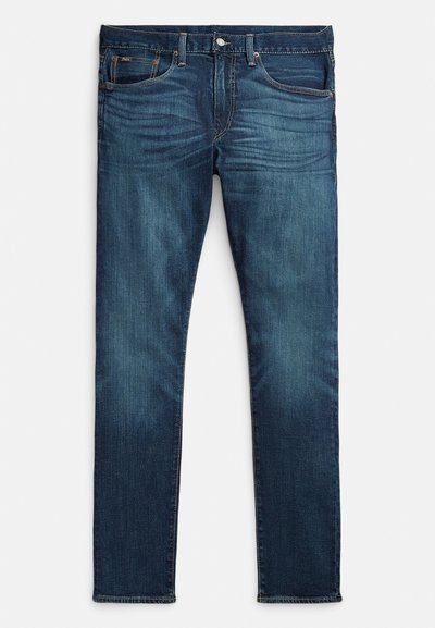 Jeans azul escuro feitos de denim, com um corte slim, cinco bolsos, costura laranja contrastante e design de perna reta.