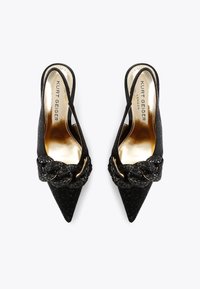 Czarne sandały na obcasie z odkrytymi piętami z szpiczastym noskiem, teksturowanym materiałem, plecionym ozdobnym wykończeniem oraz metalowym detalem na pasku. Złote logo wewnątrz.