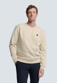 Beige crewneck sweatshirt van katoen, met een klein zwart hexagonaal logo op de linkerkant van de borst en ribgebreide manchetten en onderkant.